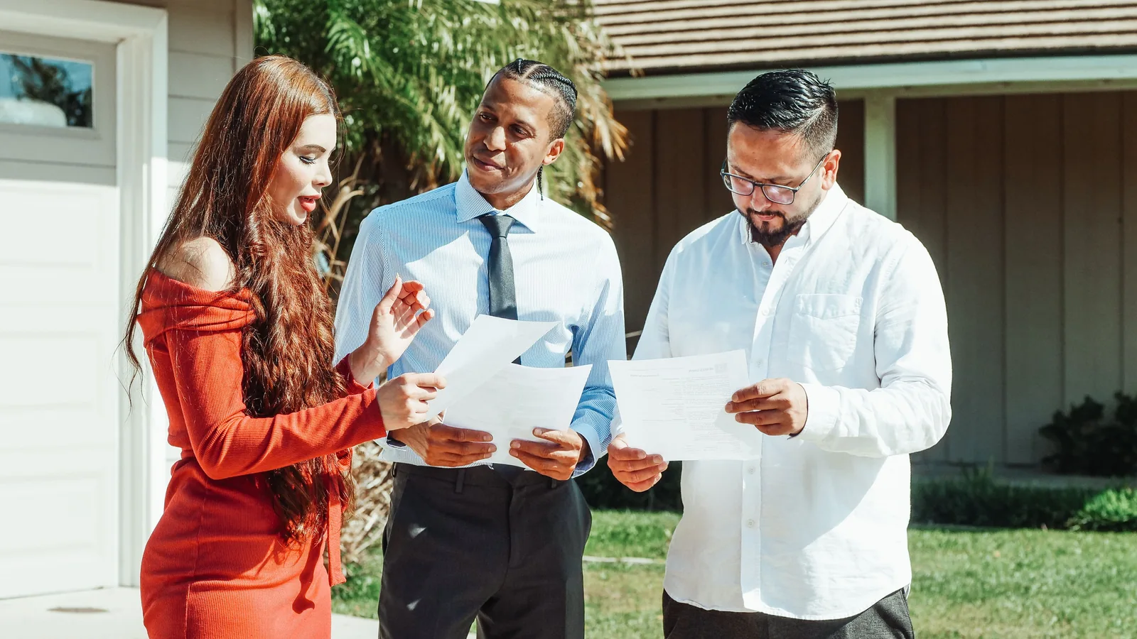 Property professionals reviewing documents outside a rental property